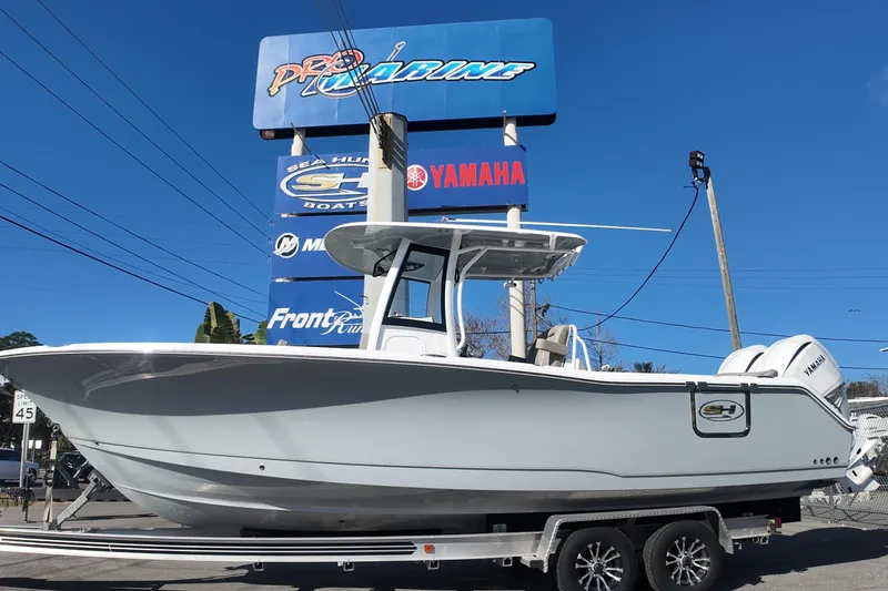 The Image of 2025 Sea Hunt Ultra 275 SE boat on trailer, displayed at dealership under clear blue sky. - 0