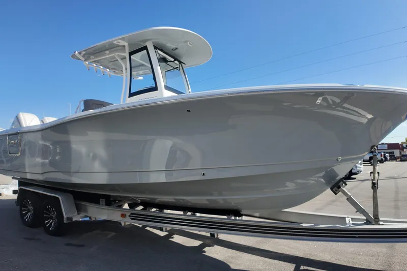 Slide: The Image of 2025 Sea Hunt Ultra 275 SE boat on trailer under clear blue sky. - 4