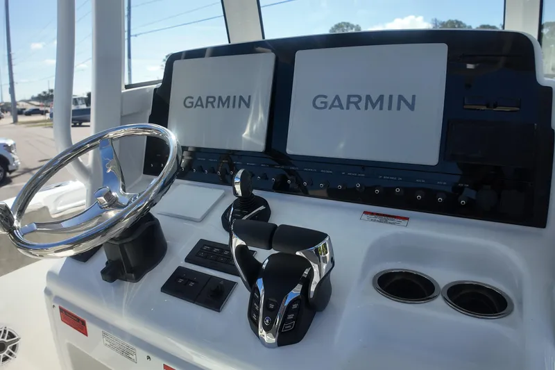 Slide: The Image of 2025 Sea Hunt Ultra 275 SE boat dashboard with Garmin navigation displays. - 13