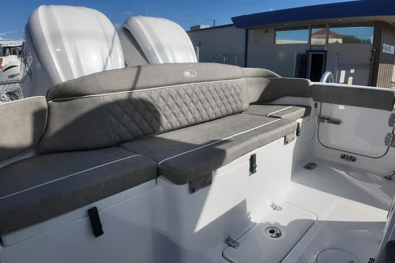 Slide: The Image of 2025 Sea Hunt Ultra 275 SE boat interior with cushioned seating and dual engines. - 16