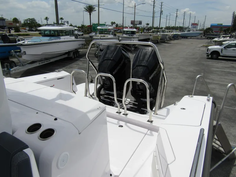 Slide: The Image of 2024 Axopar 37 Sun Top with dual outboard engines in a marina setting. - 26