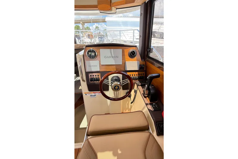 Slide: The Image of 2025 Ranger Tugs R-23 helm with Garmin navigation system and wooden steering wheel. - 3