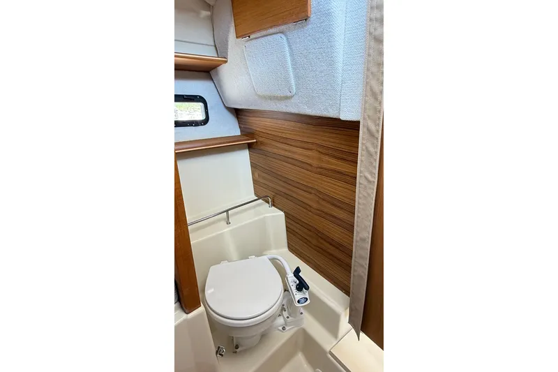 Slide: The Image of 2025 Ranger Tugs R-23 boat interior with compact bathroom and wooden accents. - 8