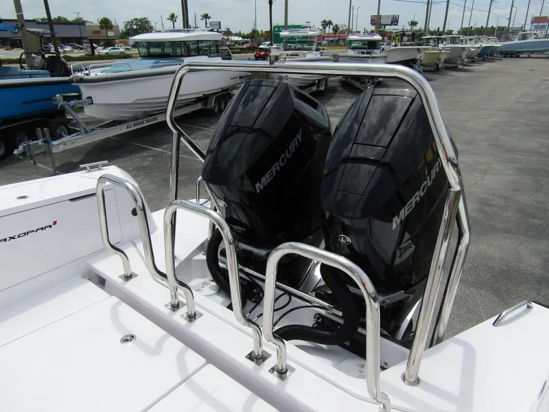 Slide: The Image of 2024 Axopar 37 Sun Top with dual Mercury outboard engines, docked in a marina. - 27