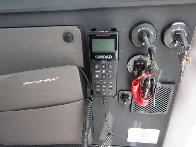 Slide: The Image of Control panel of 2024 Axopar 37 Sun Top with Simrad radio and ignition keys. - 17