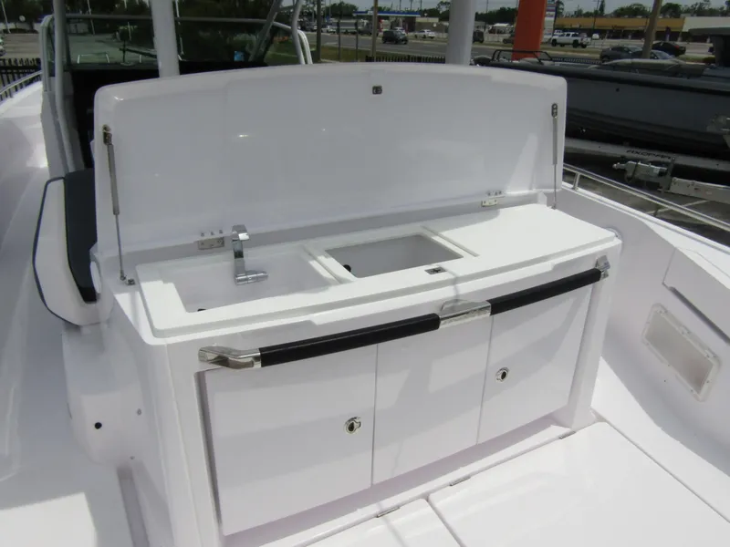 Slide: The Image of 2024 Axopar 37 Sun Top boat kitchenette with sink and storage cabinets. - 31