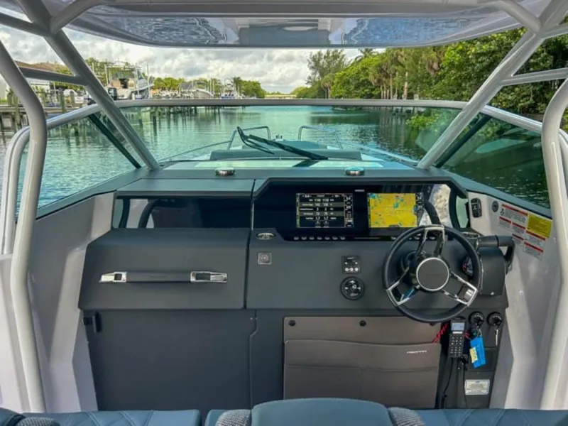 Slide: The Image of 2024 Axopar 37 Sun Top boat cockpit with modern navigation system and steering wheel. - 10