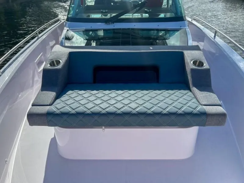 Slide: The Image of 2024 Axopar 37 Sun Top boat with cushioned seating and cup holders. - 9