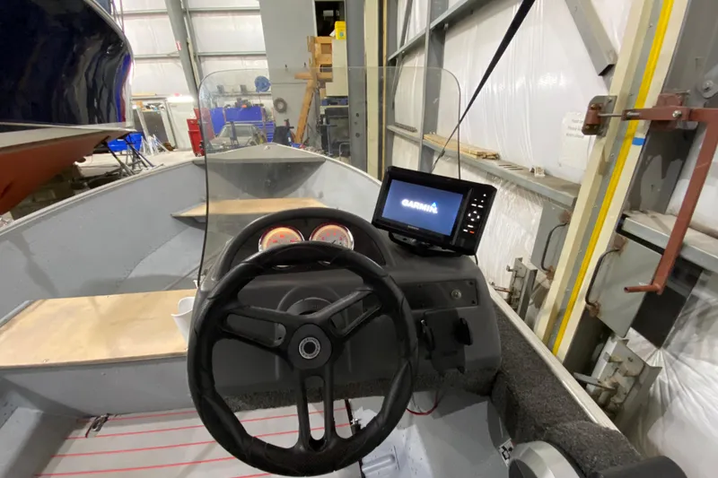 Slide: The Image of 2021 Lund SSV-18 boat interior with steering wheel and Garmin navigation system. - 11