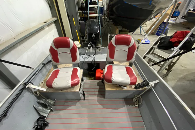 Slide: The Image of 2021 Lund SSV-18 boat interior with red and white seats in a workshop setting. - 7