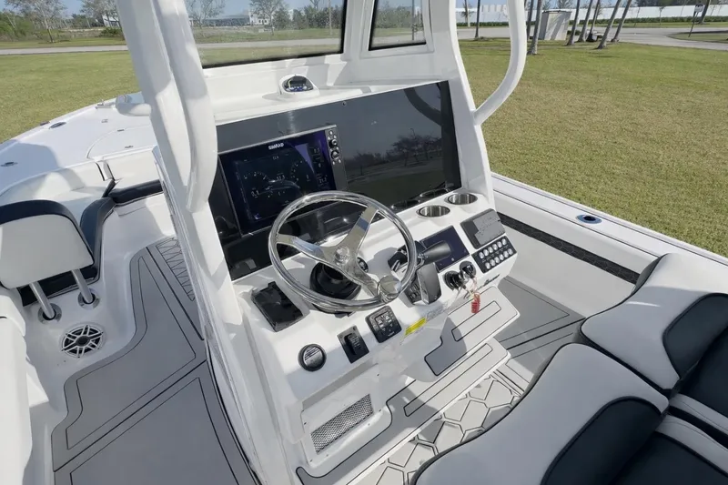 Slide: The Image of 2024 Tidewater 2500 Carolina Bay boat console with steering wheel and navigation display. - 22