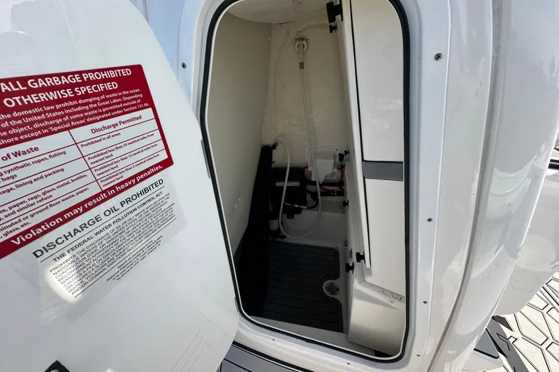 Slide: The Image of 2024 Tidewater 2500 Carolina Bay boat interior with waste disposal warning sign. - 26
