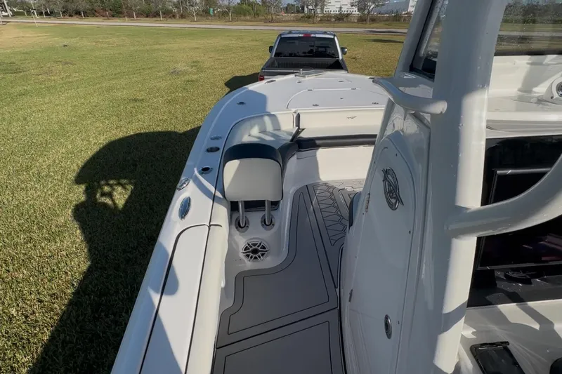 Slide: The Image of 2024 Tidewater 2500 Carolina Bay boat interior with seating and console, parked on grass. - 27