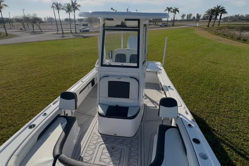 Slide: The Image of 2024 Tidewater 2500 Carolina Bay boat on grassy area with palm trees in background. - 37