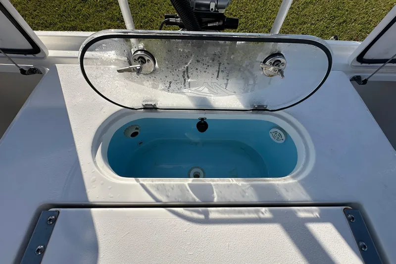 Slide: The Image of 2024 Tidewater 2500 Carolina Bay livewell with open lid, showcasing interior design. - 49