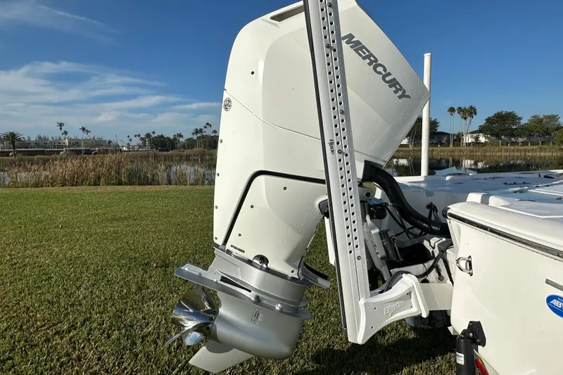 Slide: The Image of 2024 Tidewater 2500 Carolina Bay boat with Mercury outboard engine, parked on grass by water. - 54