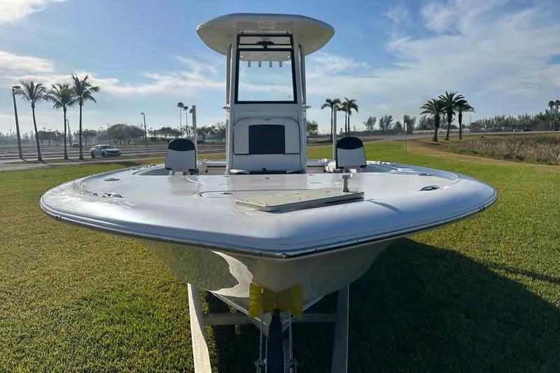Slide: The Image of 2024 Tidewater 2500 Carolina Bay boat on trailer, parked on grass under clear blue sky. - 7