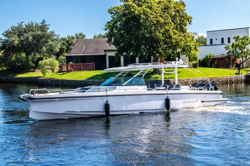 Slide: The Image of 2024 Axopar 37 Sun Top cruising on a scenic river near lush greenery. - 2