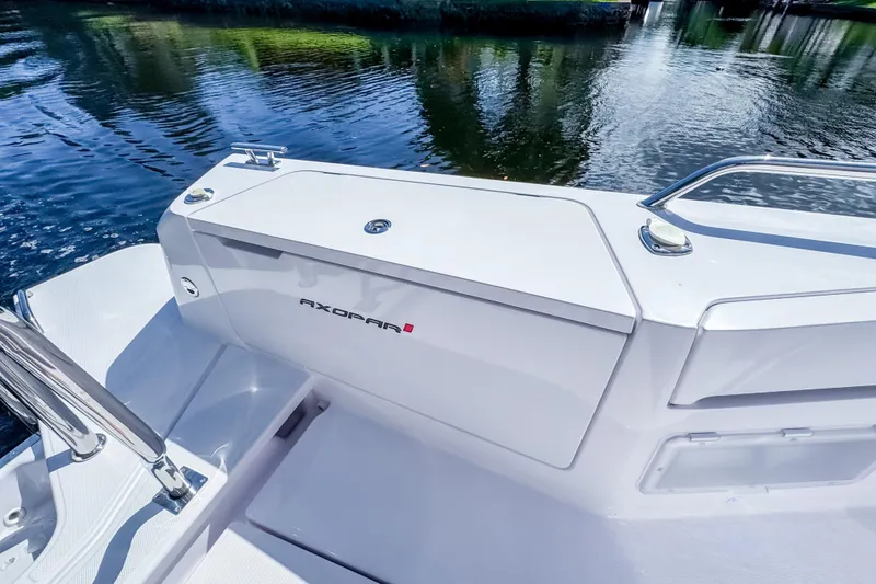 Slide: The Image of 2024 Axopar 37 Sun Top boat detail, sleek design by the water. - 10