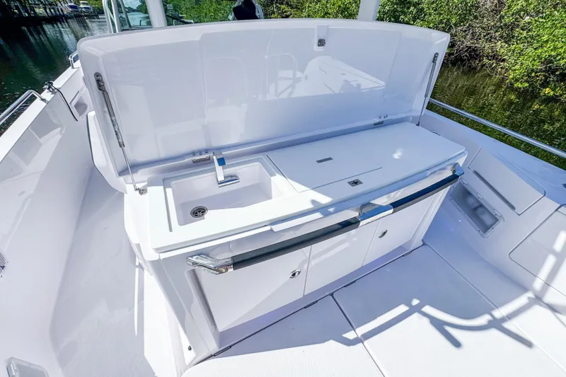Slide: The Image of 2024 Axopar 37 Sun Top boat with sleek outdoor kitchen and sink. - 12