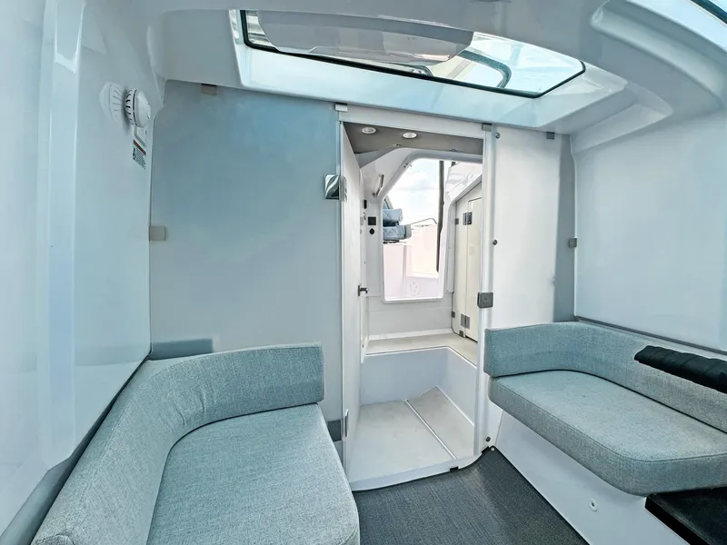 Slide: The Image of 2024 Axopar 37 Sun Top interior with modern seating and skylight. - 23