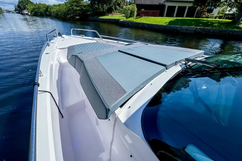 Slide: The Image of 2024 Axopar 37 Sun Top boat on a serene waterway, featuring sleek design and comfortable seating. - 25