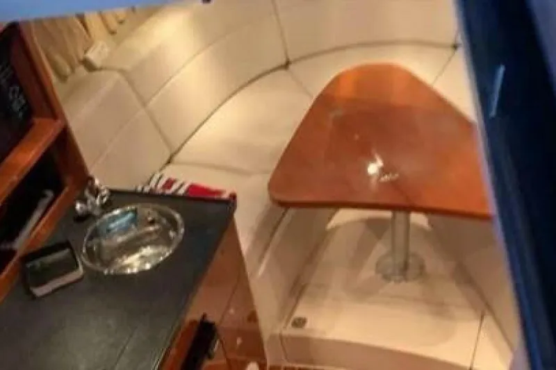 Slide: The Image of Interior of 2006 Regal 3060 Window Express boat with sink and wooden table. - 11