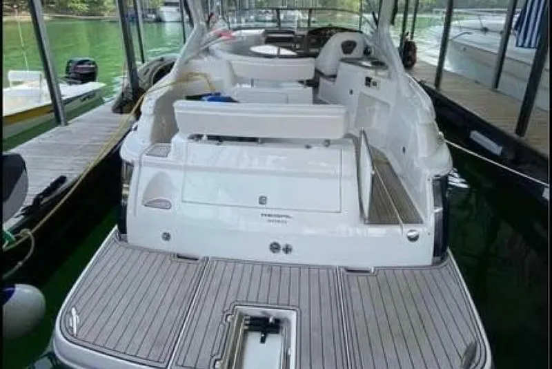 Slide: The Image of 2006 Regal 3060 Window Express boat docked, featuring spacious deck and seating area. - 17