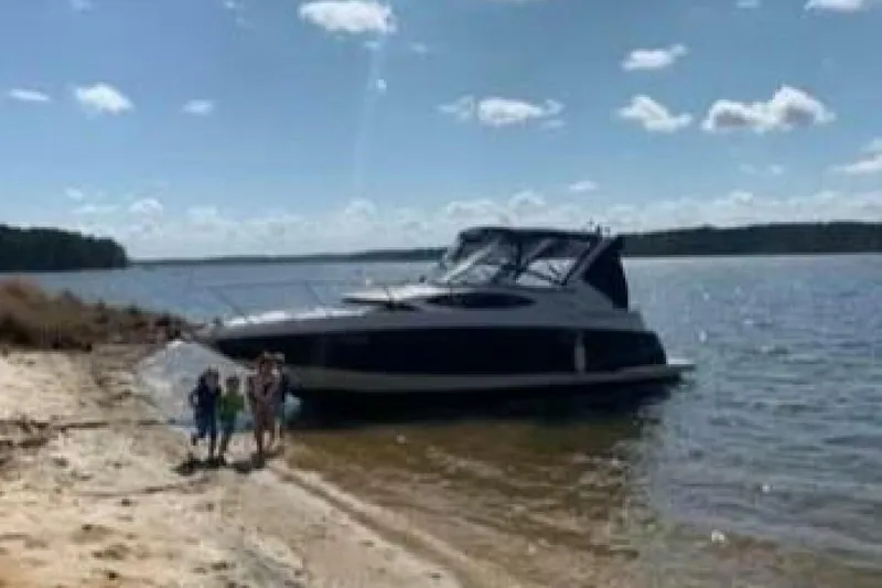 Slide: The Image of 2006 Regal 3060 Window Express boat beached on a sunny shoreline with people nearby. - 5