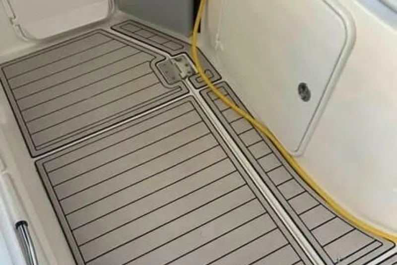 Slide: The Image of 2006 Regal 3060 Window Express boat deck with yellow cable and storage compartment. - 8