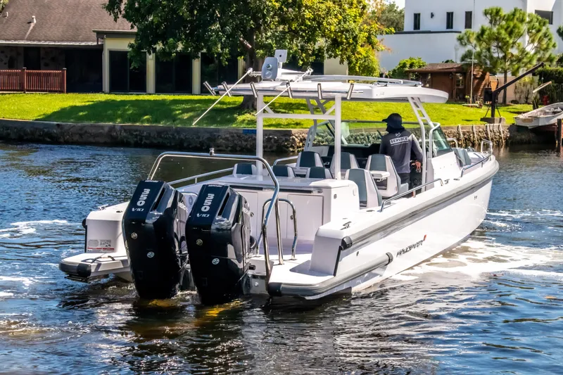 Slide: The Image of 2024 Axopar 37 Sun Top boat cruising on a sunny day with dual outboard engines. - 33