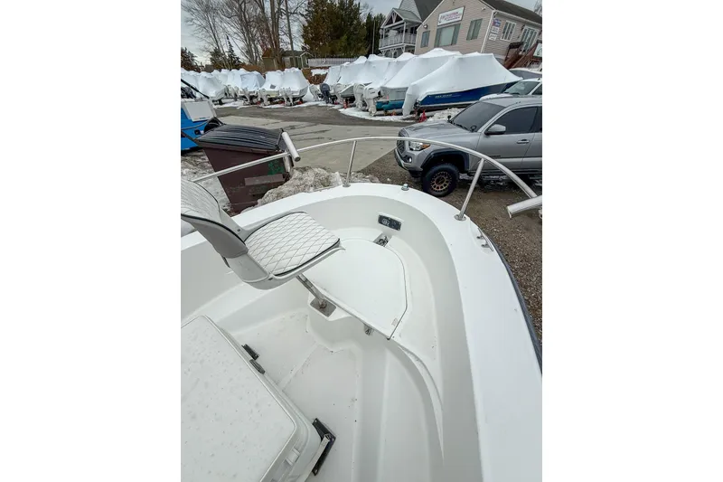 Slide: The Image of 1999 Boston Whaler 18 Dauntless boat in storage yard, surrounded by covered boats. - 10