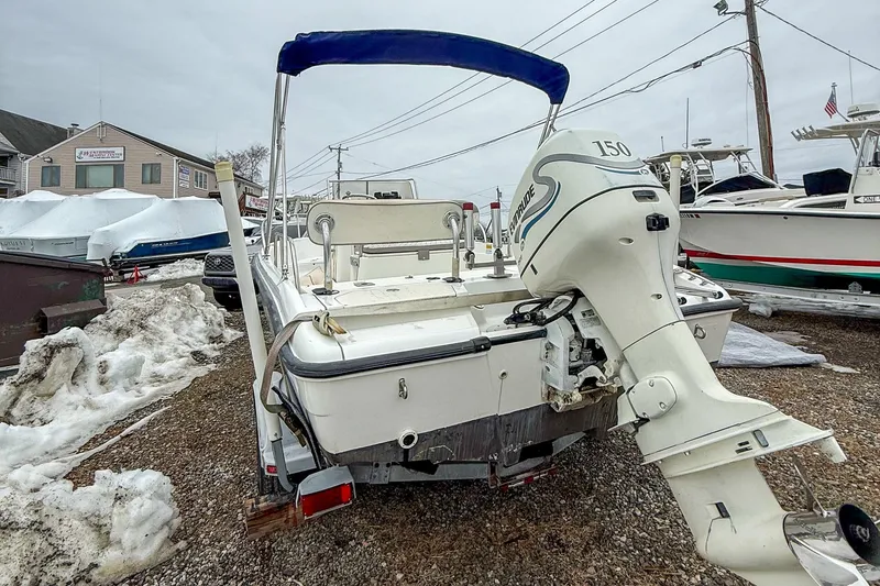 Slide: The Image of 1999 Boston Whaler 18 Dauntless boat with Evinrude 150 outboard motor, parked on snowy ground. - 2
