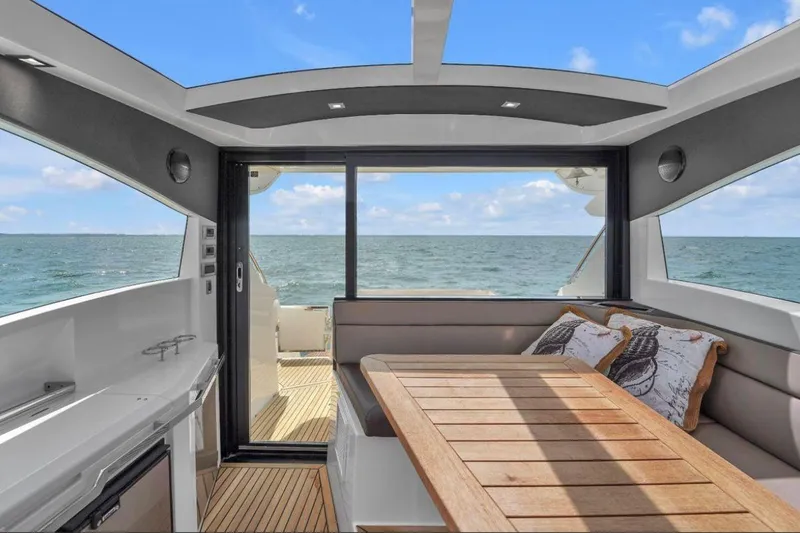Slide: The Image of Interior of 2017 Galeon 445 HTS yacht with ocean view and wooden table. - 18
