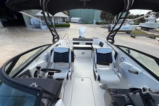 Slide: The Image of 2021 Monterey M-65 boat interior with seating and steering wheel, docked at marina. - 2