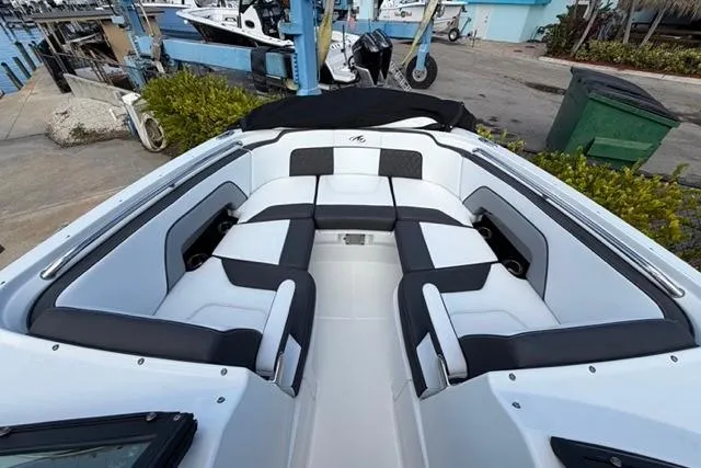 Slide: The Image of 2021 Monterey M-65 boat interior with sleek white and black seating at a marina. - 5