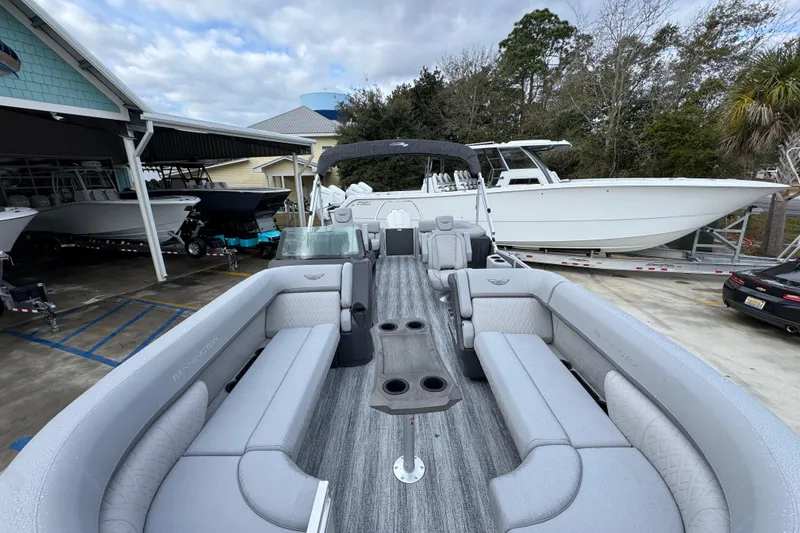 Slide: The Image of 2026 Bennington 24 MFB pontoon boat with spacious seating, docked near other boats. - 17