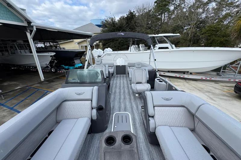 Slide: The Image of 2026 Bennington 24 MFB pontoon boat with luxurious seating and sleek design in a marina. - 18