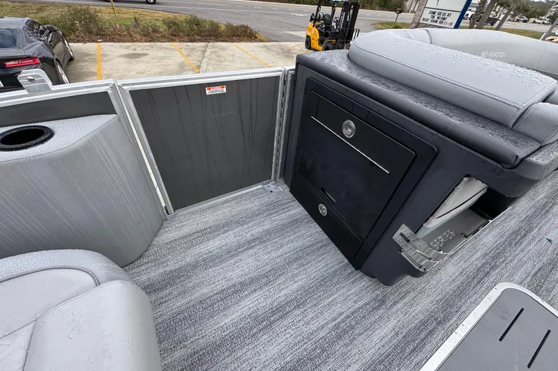 Slide: The Image of 2026 Bennington 24 MFB boat interior with seating and storage, wet from rain. - 21
