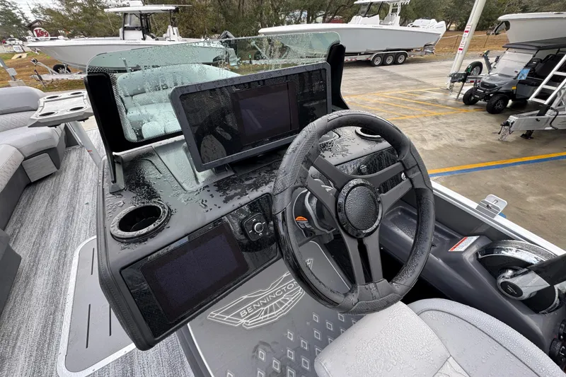 Slide: The Image of 2026 Bennington 24 MFB boat dashboard with steering wheel and digital displays. - 24