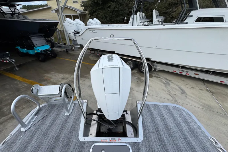 Slide: The Image of 2026 Bennington 24 MFB boat with Mercury outboard motor in a marina setting. - 30