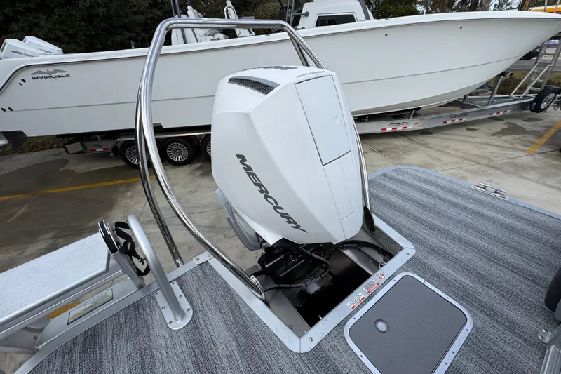 Slide: The Image of 2026 Bennington 24 MFB boat with Mercury outboard engine, parked on a trailer. - 32