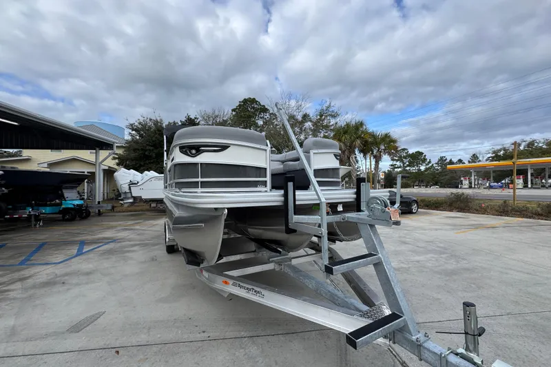Slide: The Image of 2026 Bennington 24 MFB pontoon boat on trailer, parked outdoors under cloudy sky. - 6