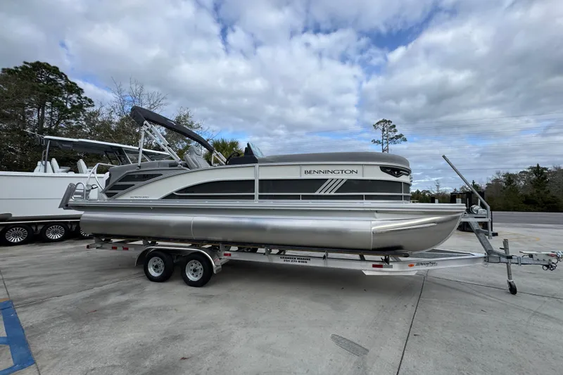 Slide: The Image of 2026 Bennington 24 MFB pontoon boat on trailer under cloudy sky. - 8