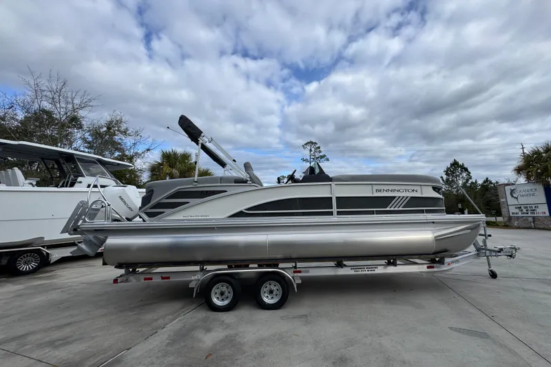 Slide: The Image of 2026 Bennington 24 MFB pontoon boat on trailer under cloudy sky. - 9
