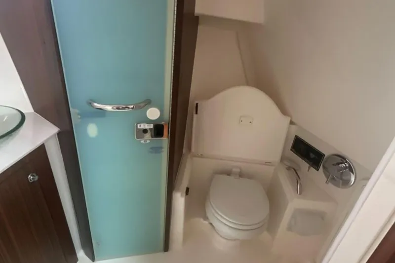 Slide: The Image of 2017 Pursuit OS 355 Offshore boat bathroom with modern fixtures and frosted glass door. - 15