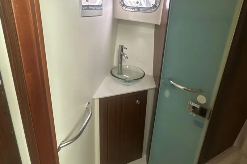 Slide: The Image of 2017 Pursuit OS 355 Offshore bathroom with glass sink and modern fixtures. - 16