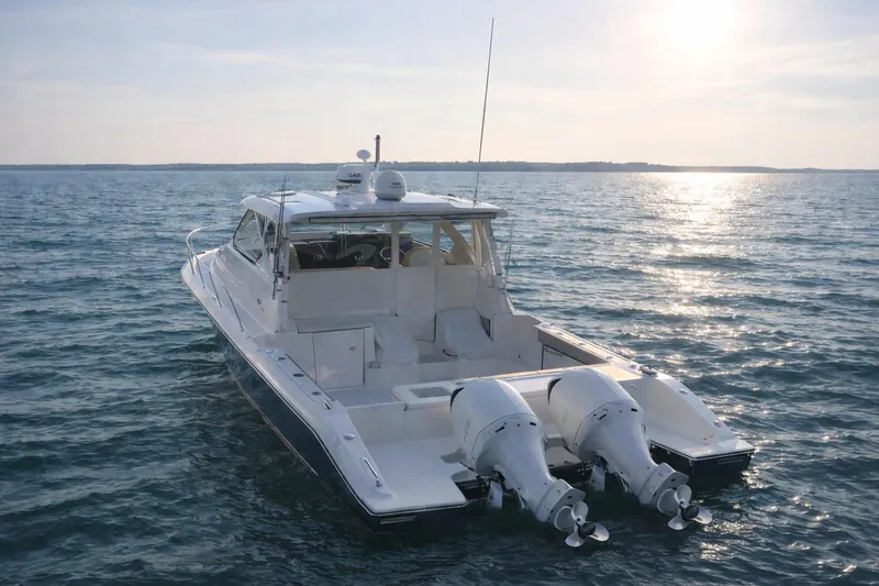 Slide: The Image of 2017 Pursuit OS 355 Offshore boat on calm water at sunset. - 3
