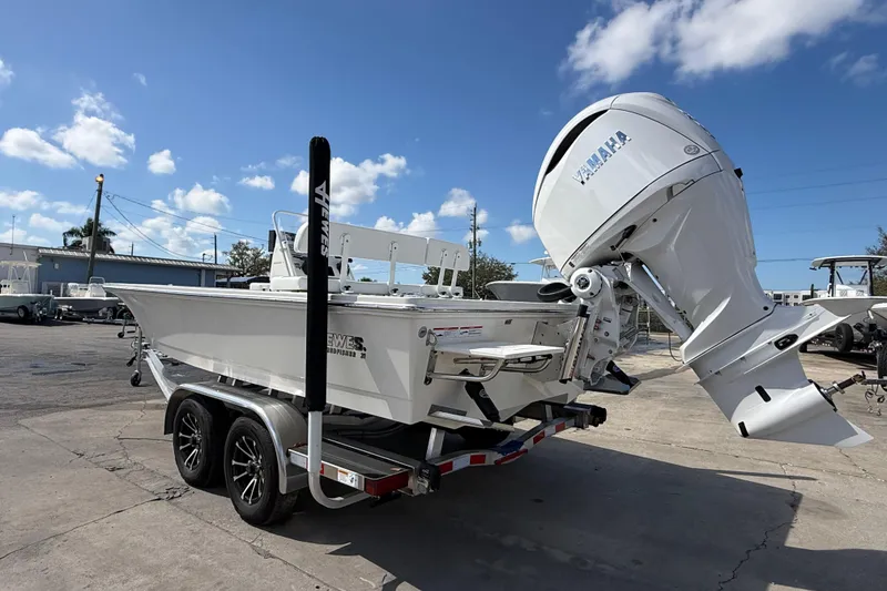 Slide: The Image of 2026 Hewes Redfisher 21 boat on trailer with Yamaha outboard motor, under clear blue sky. - 4
