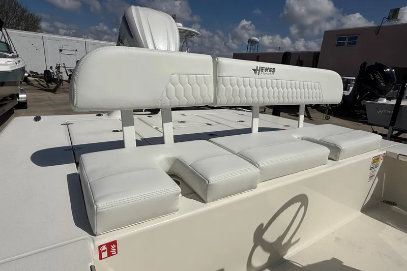 Slide: The Image of 2026 Hewes Redfisher 21 boat with white cushioned seating, outdoor setting, and clear sky. - 8